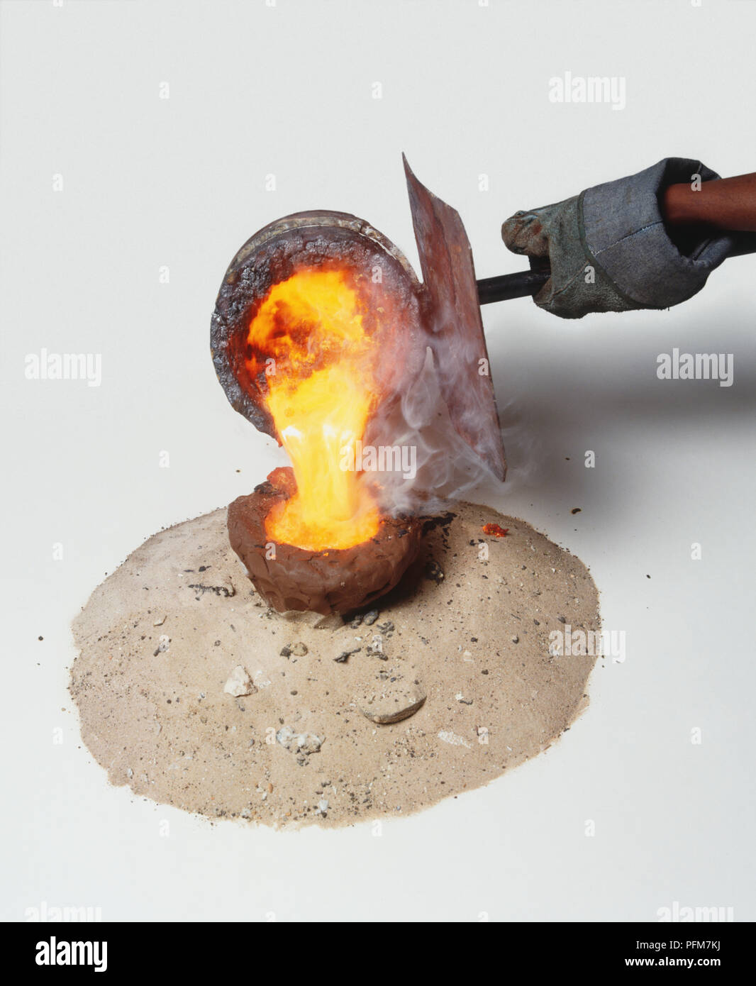 Pouring molten bronze into mould, method traditionally used in Africa Stock Photo