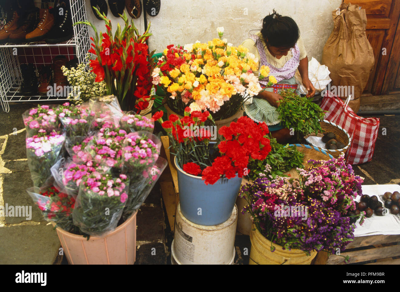 Mexico, Taxco, Plaza Borda, flower seller sitting behind a market