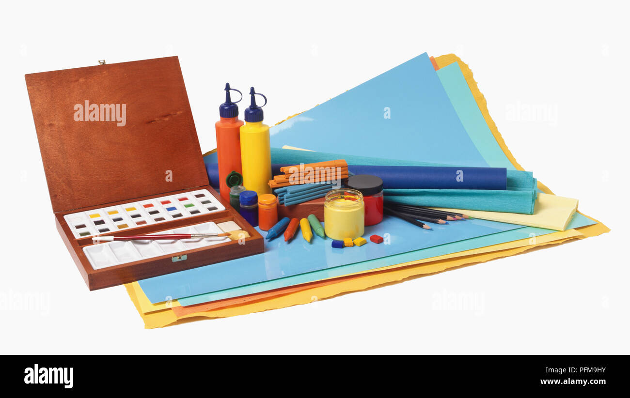 Selection of art materials, including box of watercolour blocks, bottles of paint, pencils, pastels, crayons and different coloured paper. Stock Photo