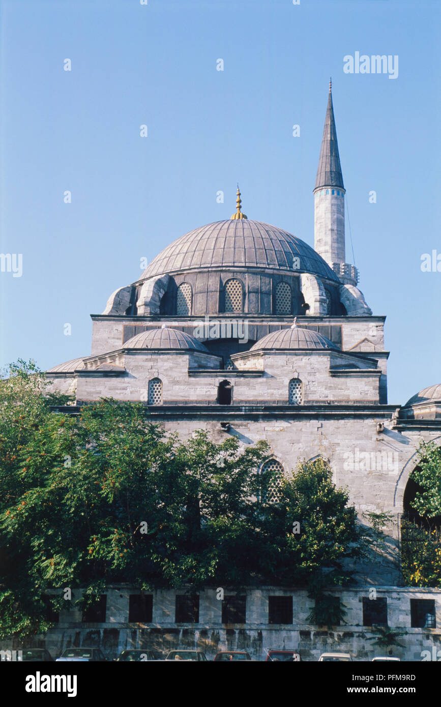Asia, Turkey, Istanbul, dome and minaret of the mosque of Atik Ali Pasa, dating from 1496, cars parked beside mosque wall, blue sky above. Stock Photo