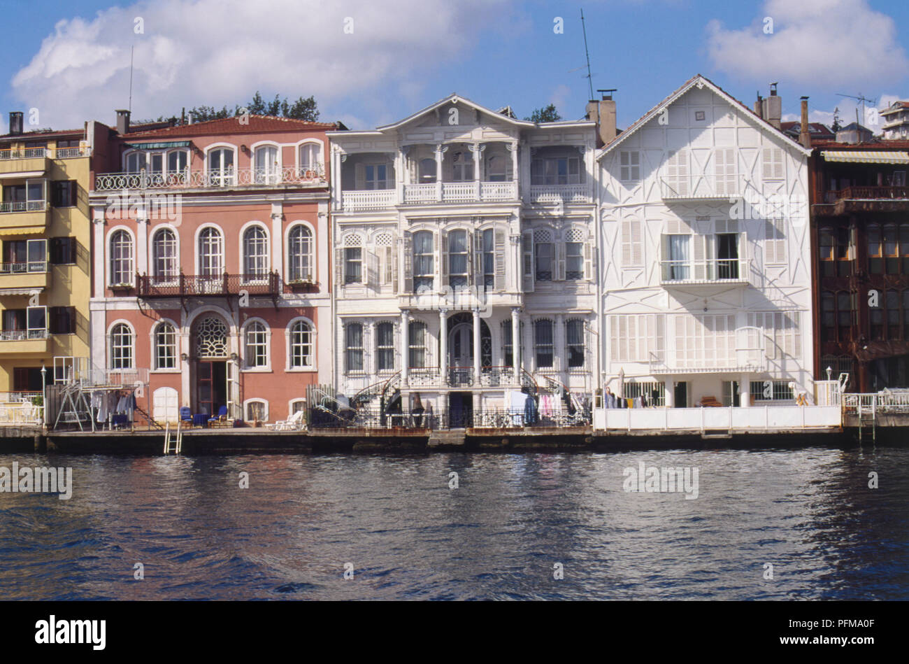 Asia, Turkey, Yenikoy, handsome 19th-century villas dating from Byzantine times lining waterfront, various styles and colours with balconies, blue sky above. Stock Photo