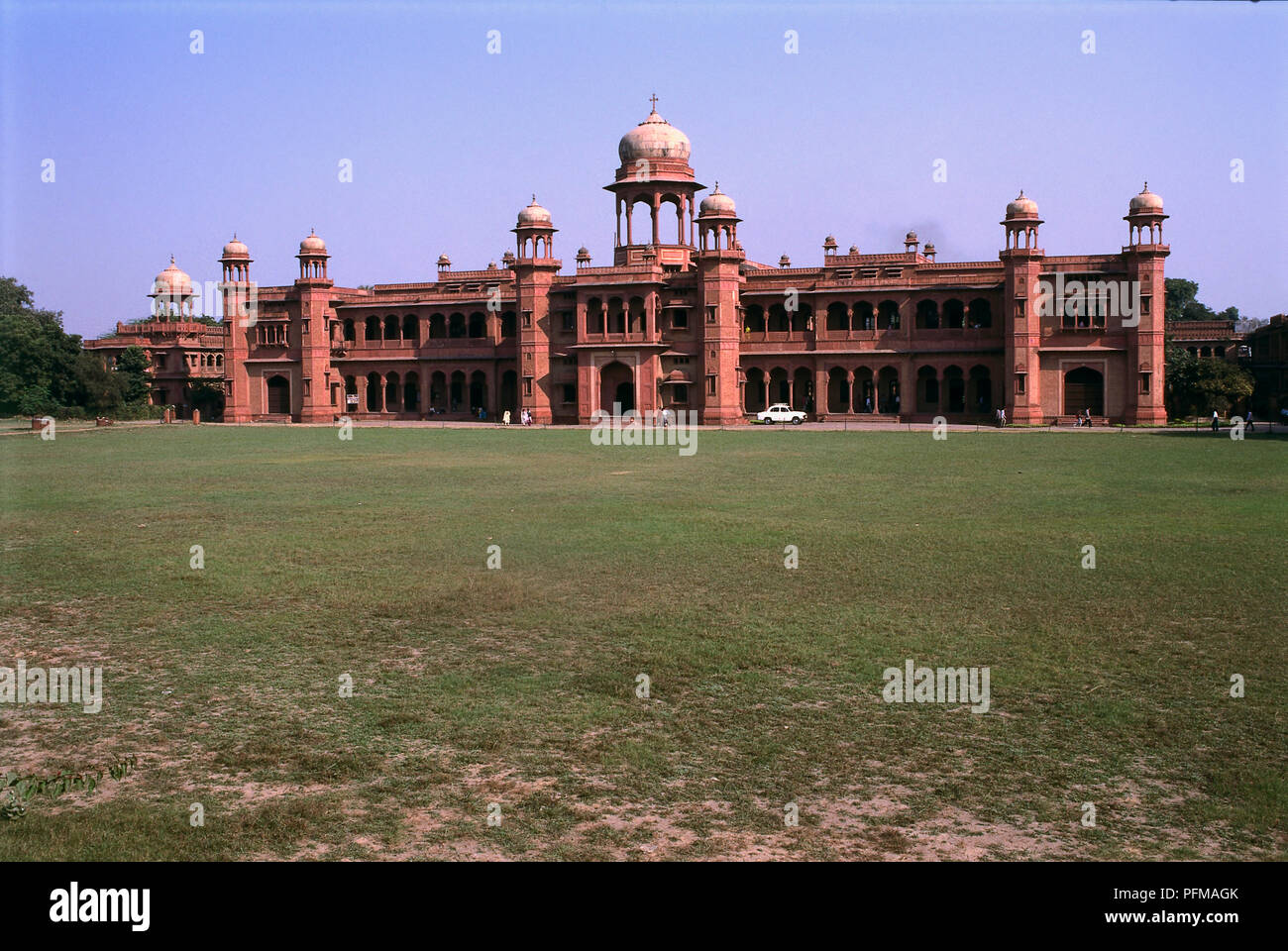 India, Agra, St John's College, red sandstone building with small white domes, cross on central dome, porticoed facade, founded by Church Missionary Society, car parked outside, large lawn in foreground. Stock Photo