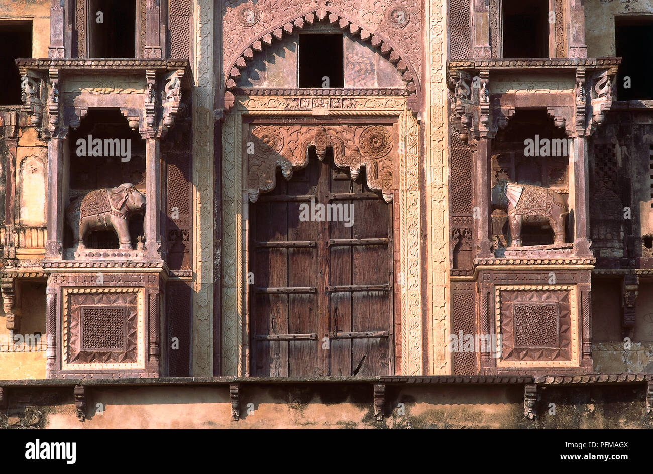 India, Jahangiri Mahal, Rajput Bundela architecture, impressively fringed entrance gateway, red sandstone, flanked by stone elephants. Stock Photo