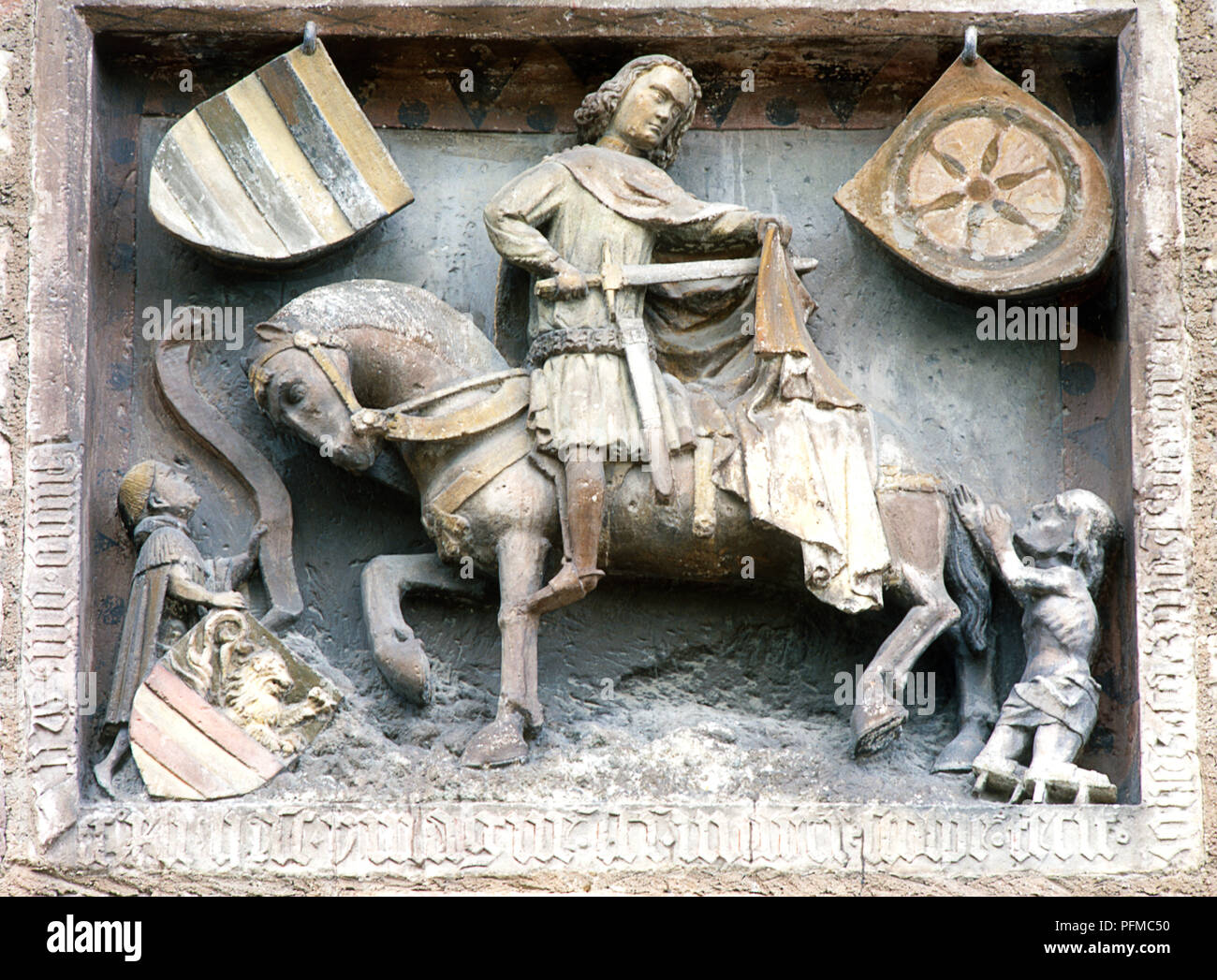 Germany, Hesse, Fritzlar, relief statue of St Martin on horse surrounded by beggars, on the walls of the medieval town hall, built c. 12th century Stock Photo