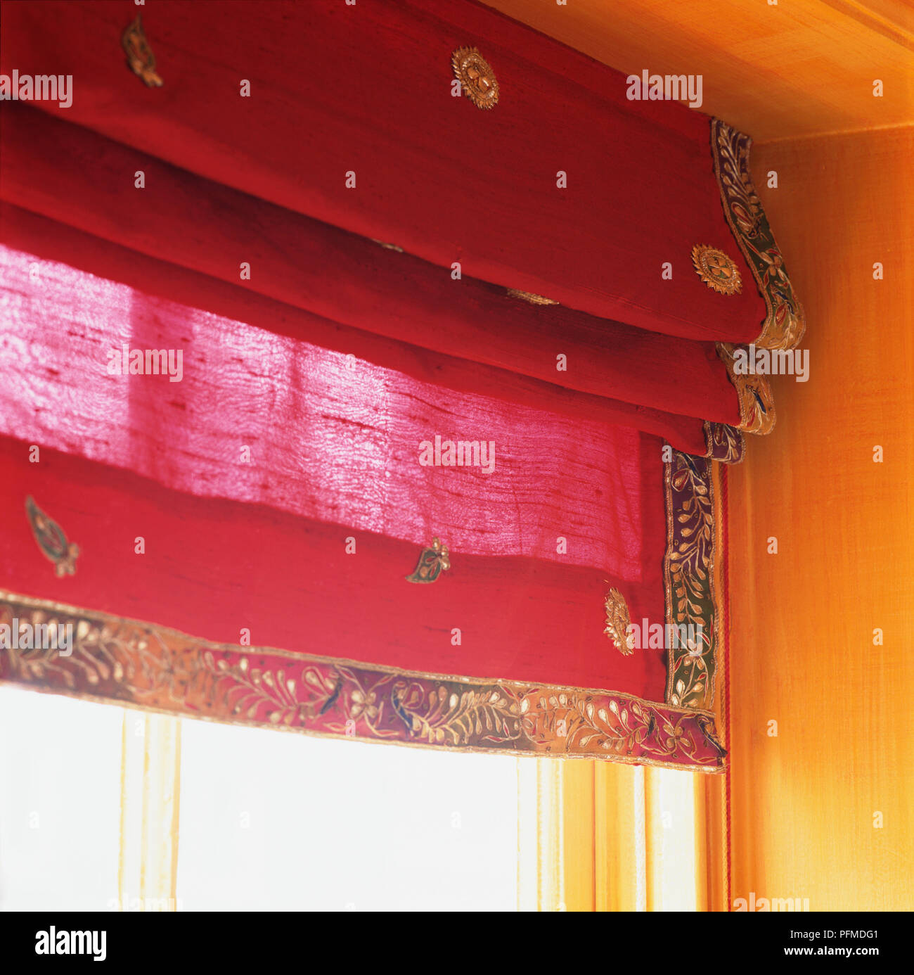 Indianstyle red blinds with gold edging and details, hanging over