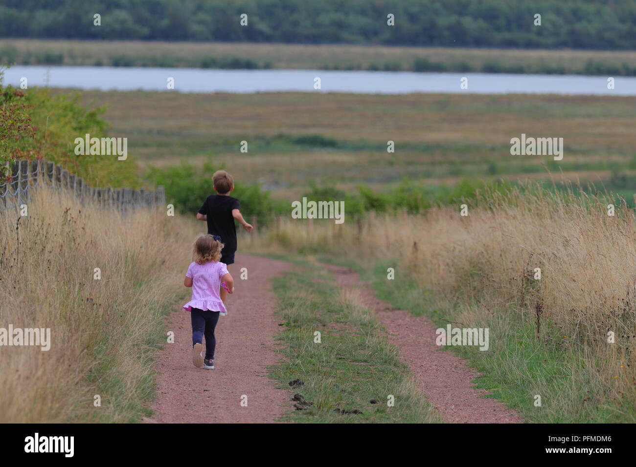 Brother & Sister running away on St Aidan's Nature Park Stock Photo - Alamy