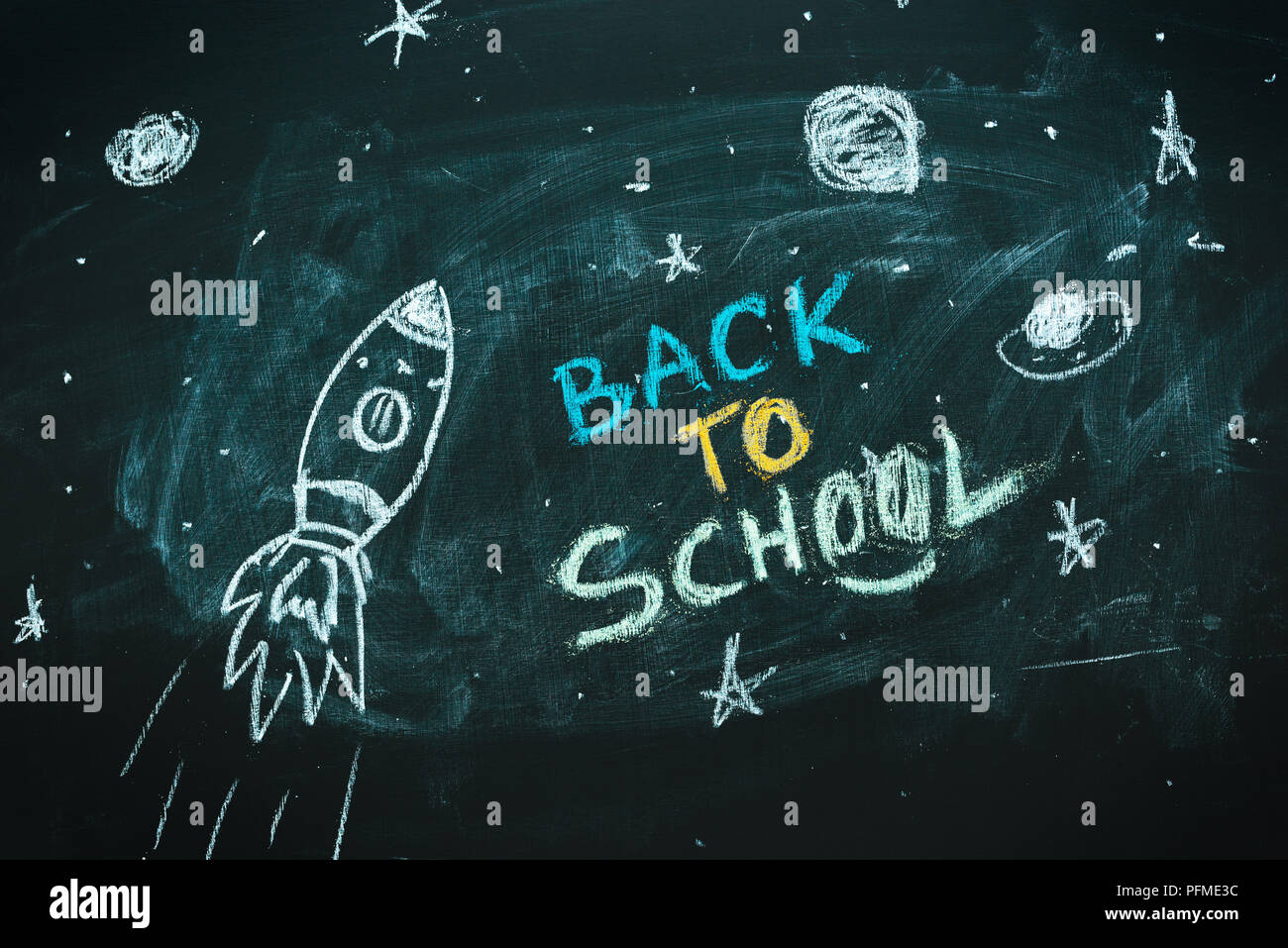 Space rocket with planets and stars doodle drawing on chalkboard, back to school concept Stock Photo