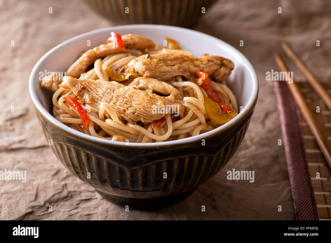 A bowl of delicious honey garlic noodles with chicken and peppers. Stock Photo