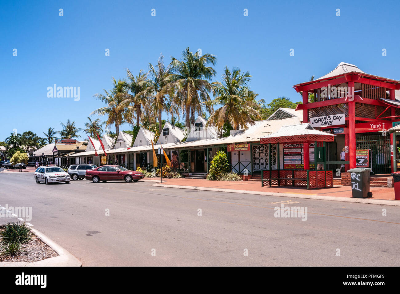 Broome, WA, Australia - November 29, 2009: Street view with cars and people in front of white and red Johnny Chi Lane shopping mall with palm trees an Stock Photo