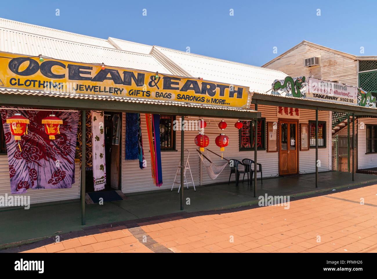 Broome, WA, Australia - November 29, 2009: Ocean and Earth souvenir shop in row of businesses sells clothing, gifts, jewelry and more. Blue sky and ch Stock Photo