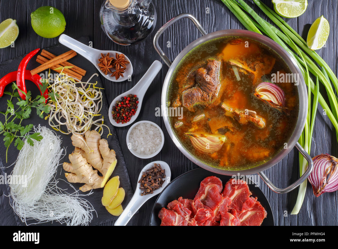 ingredients of Vietnamese soup Pho Bo, with raw beef, bone broth in a stainless pan, soy sprouts