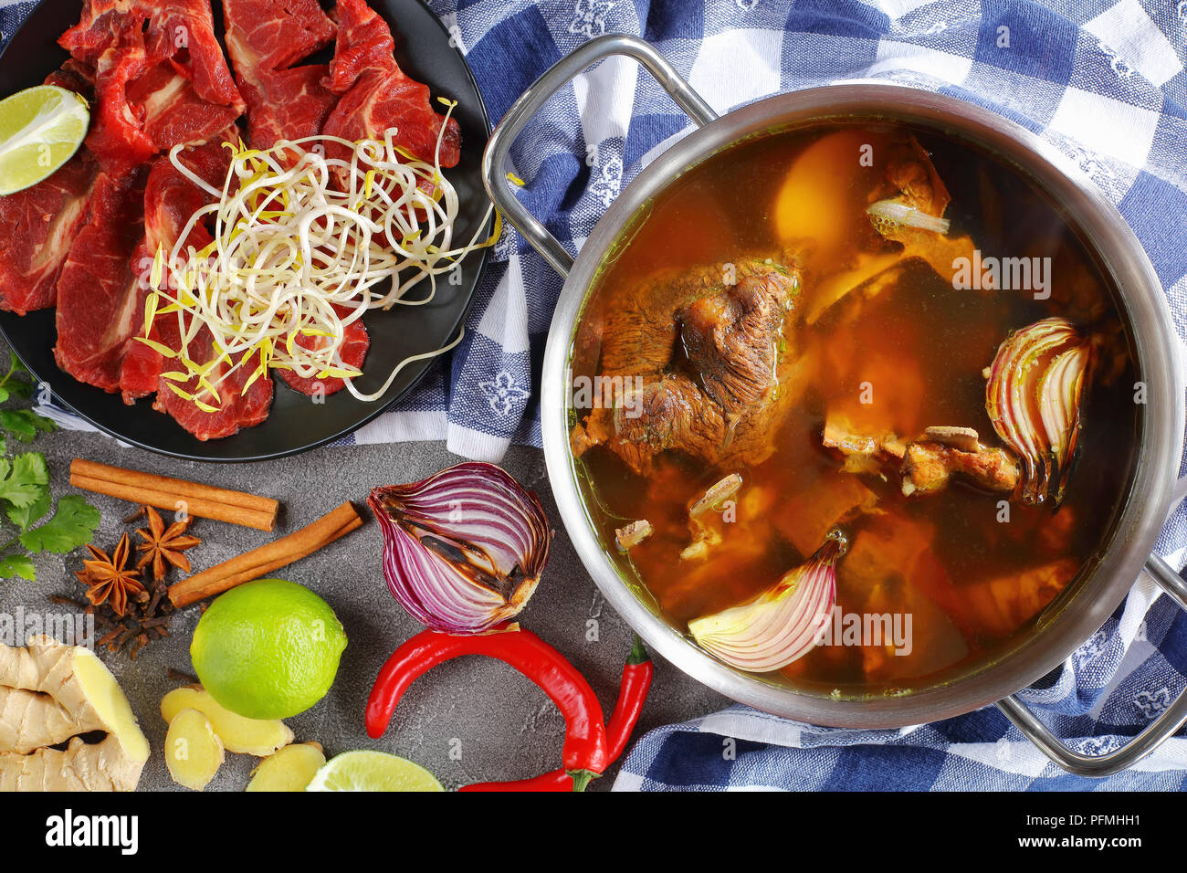 closeup of hot beef bone broth and other ingredients for traditional Vietnamese soup Pho Bo
