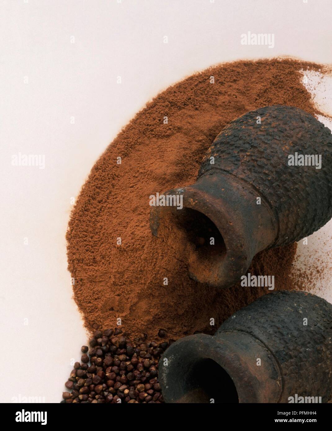 Powdered Cola acuminata (Kola nut) and Aframomum melegueta (Grains of paradise) spilling out of clay jars Stock Photo