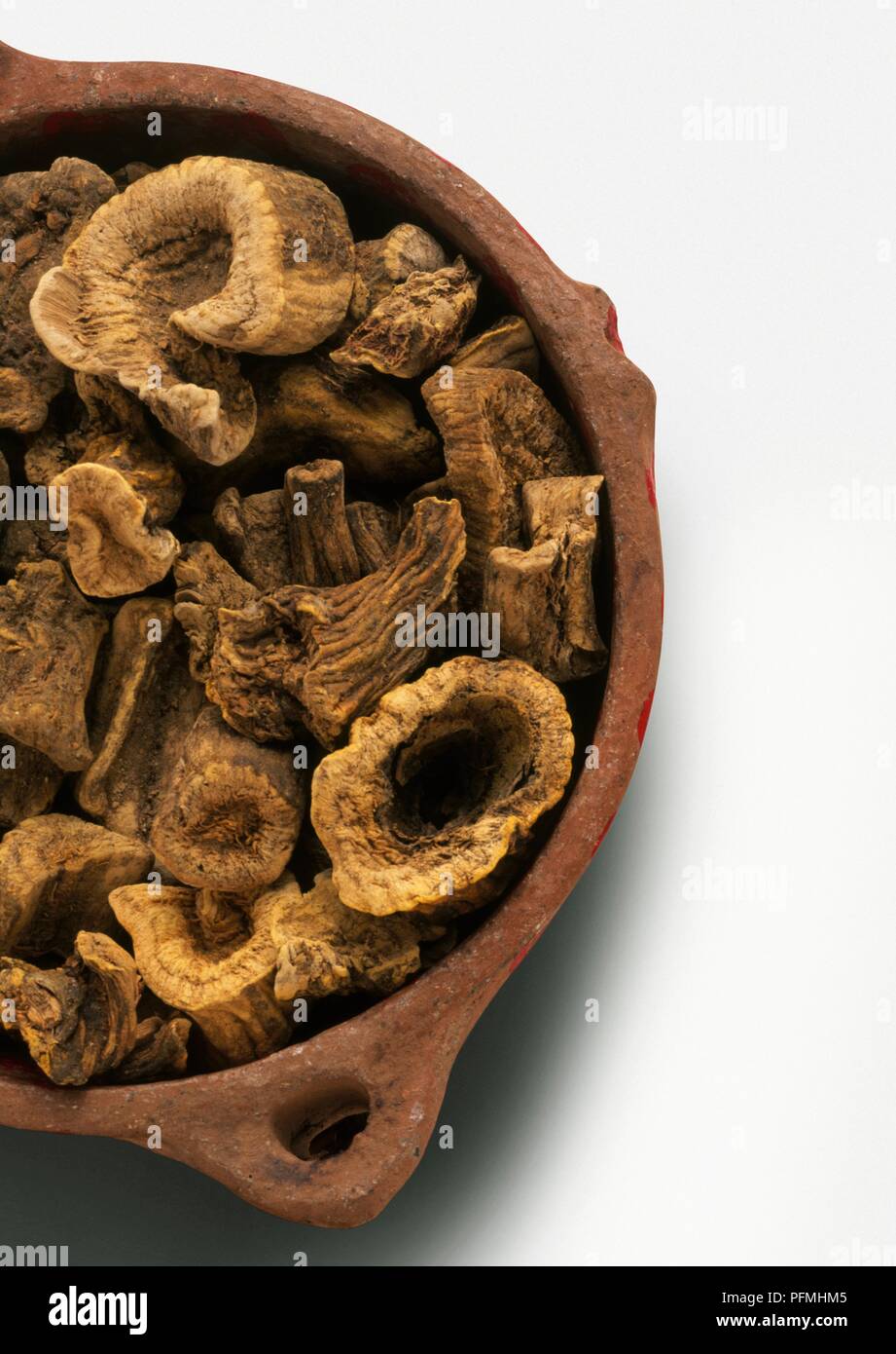 Clay bowl containing dried root slices of Jateorhiza palmata (Calumba), close-up Stock Photo