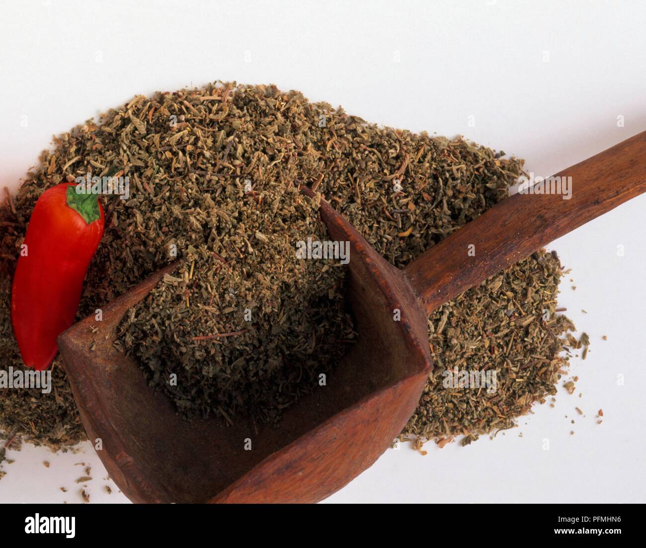 Dried leaves from Turnera diffusa (Damiana), wooden scoop, and cayenne pepper Stock Photo