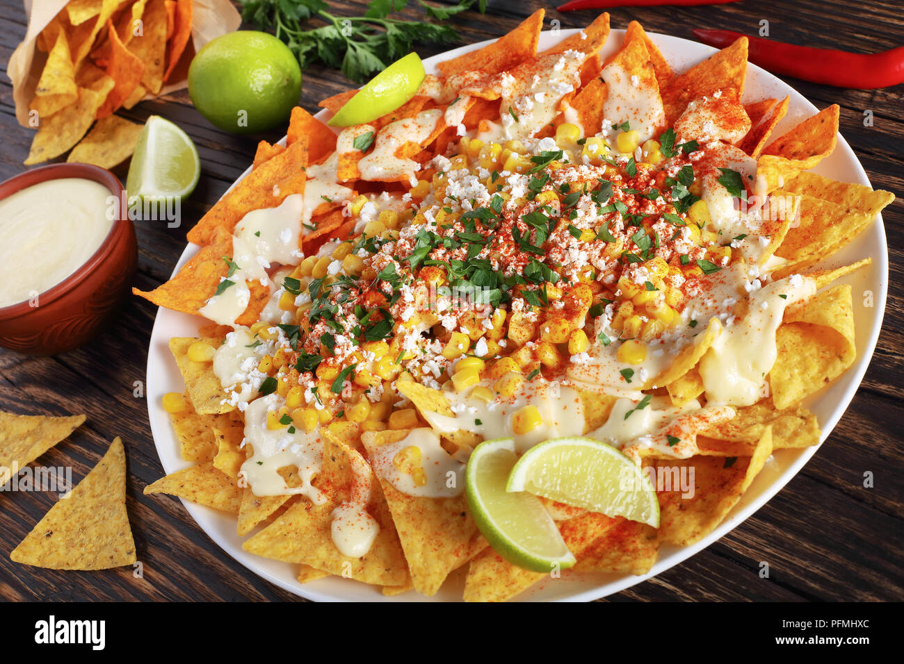 nachos or Tortilla chips topped a melted creamy cheese sauce, corn