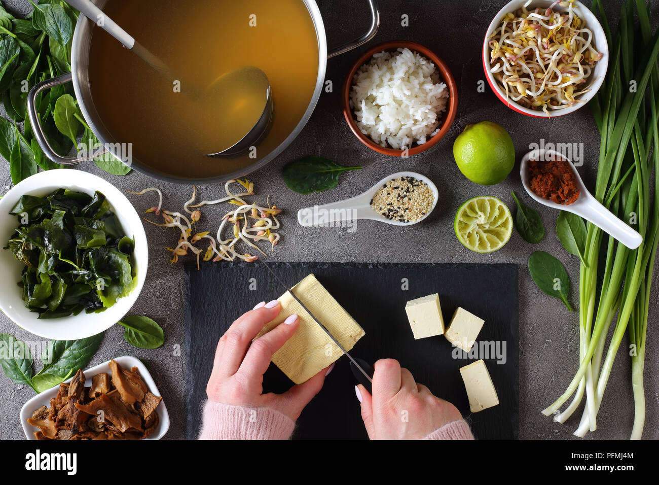 woman is cutting tofu into cubes for traditional japanese miso soup