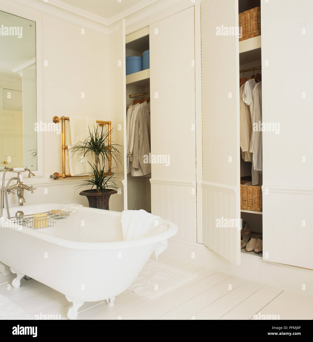 Stand-alone bath next to fitted wardrobes. Stock Photo