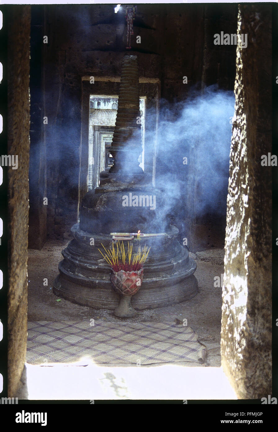 Sunlight streaming through a window of a room filled with smoke from an incense burner in Buddhist Monastery Stock Photo