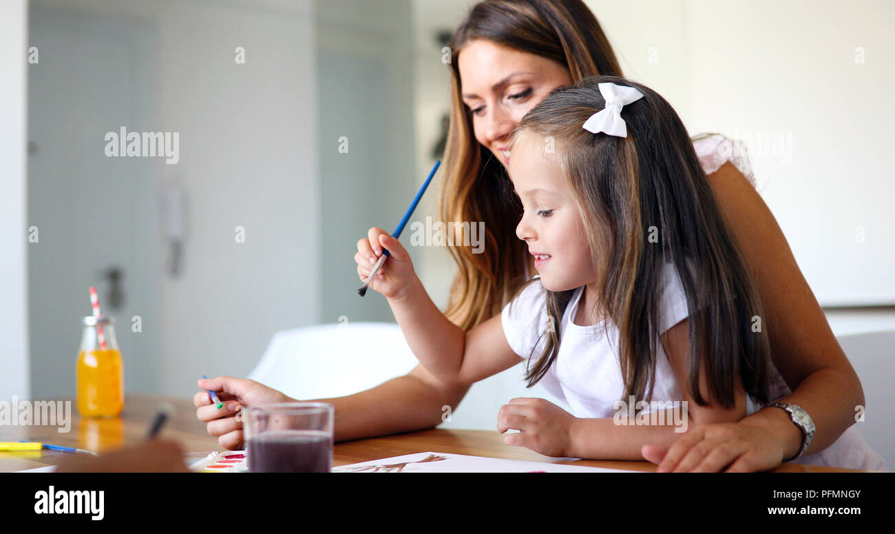 Little girl painting with her mother at home Stock Photo - Alamy