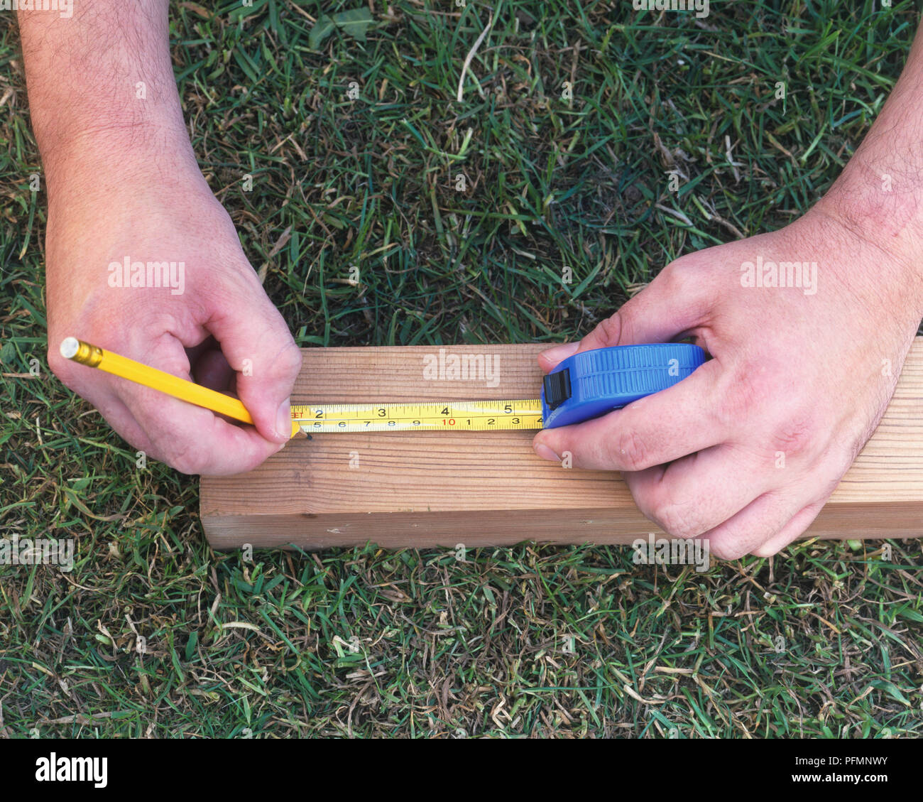 Marking wooden post using tape measure and pencil Stock Photo Alamy