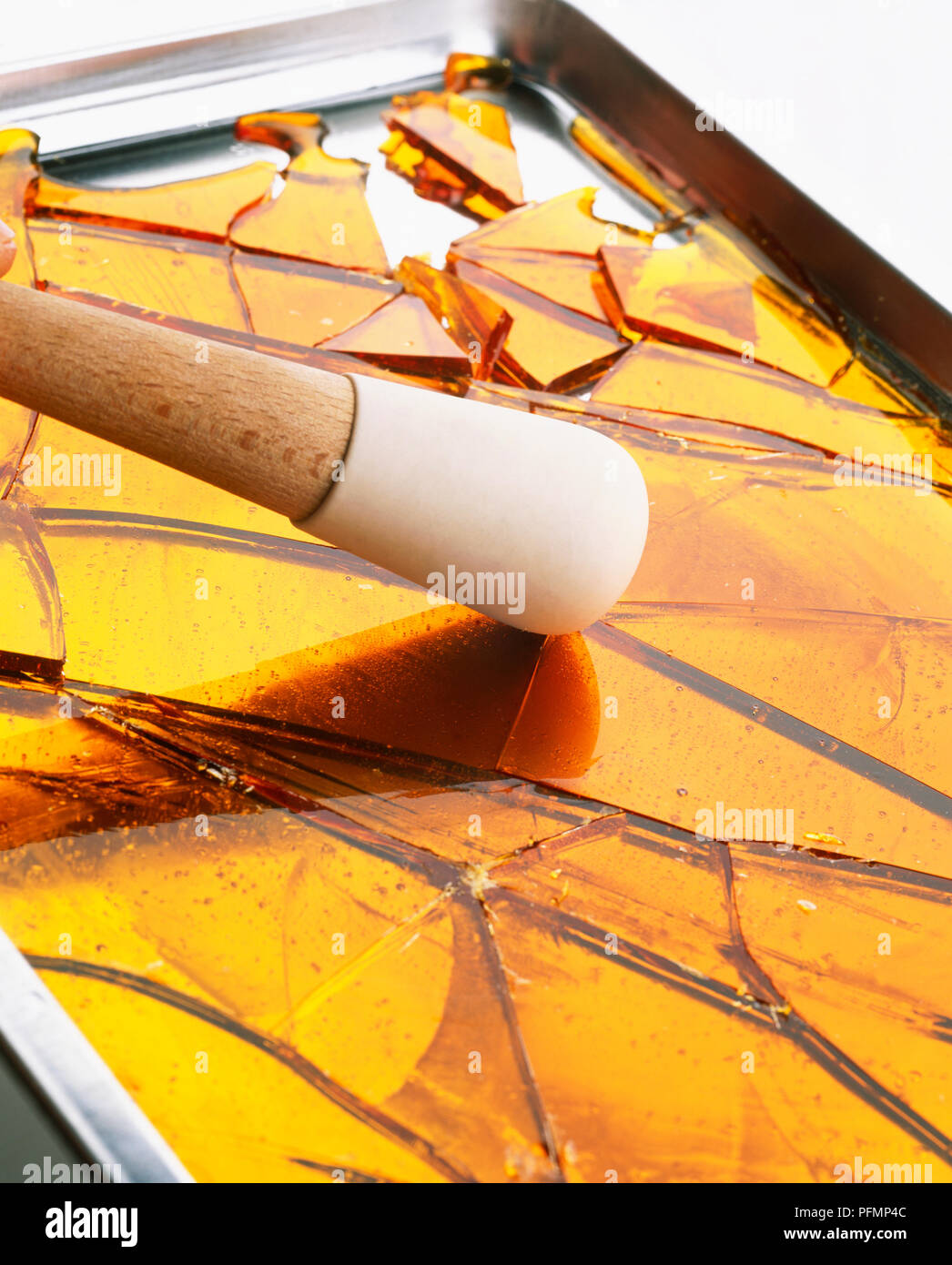 Using pestle to break hardened caramel into shards Stock Photo Alamy