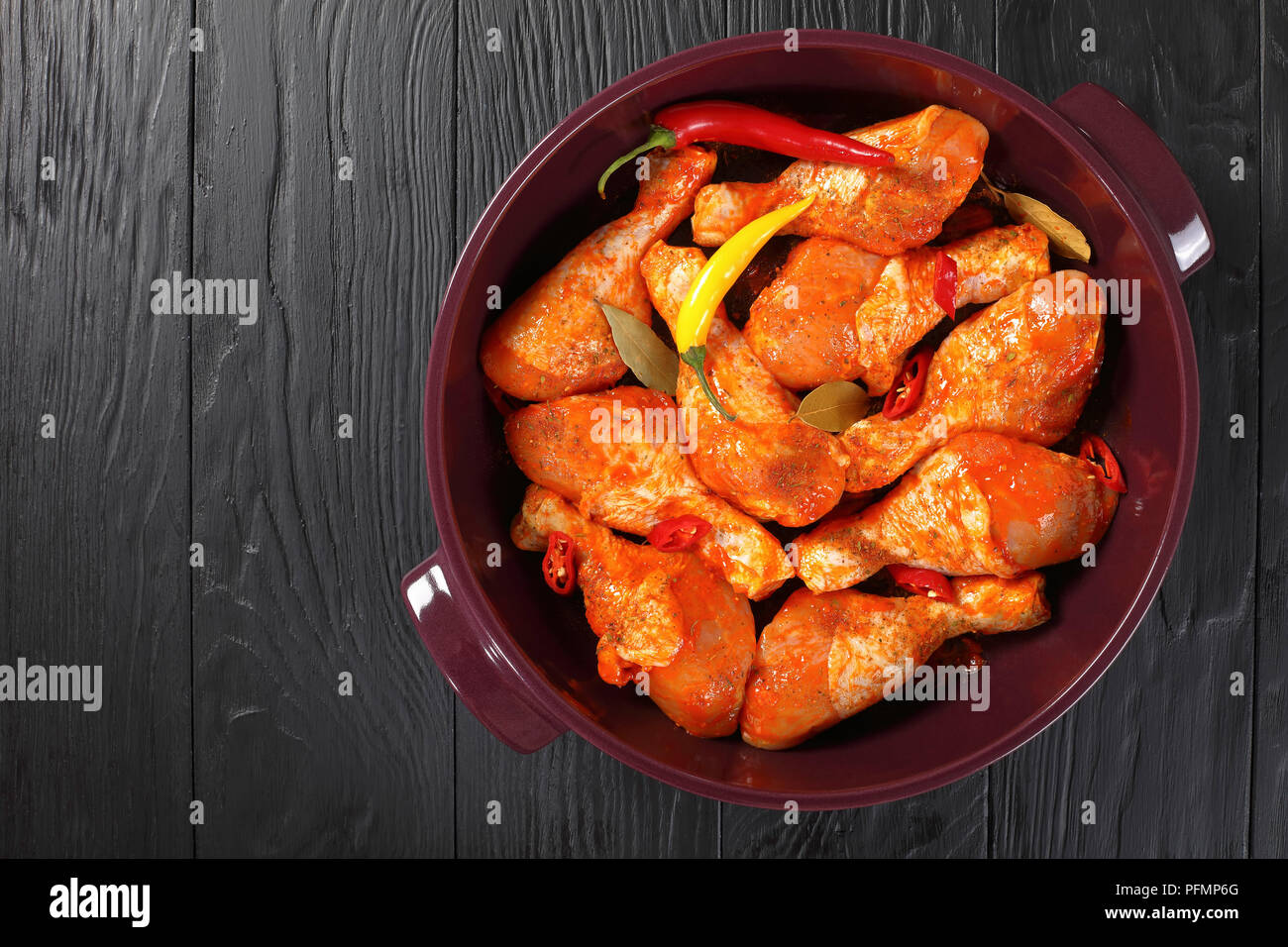 raw marinated chicken drumsticks rubbed with finely ground spice, chili