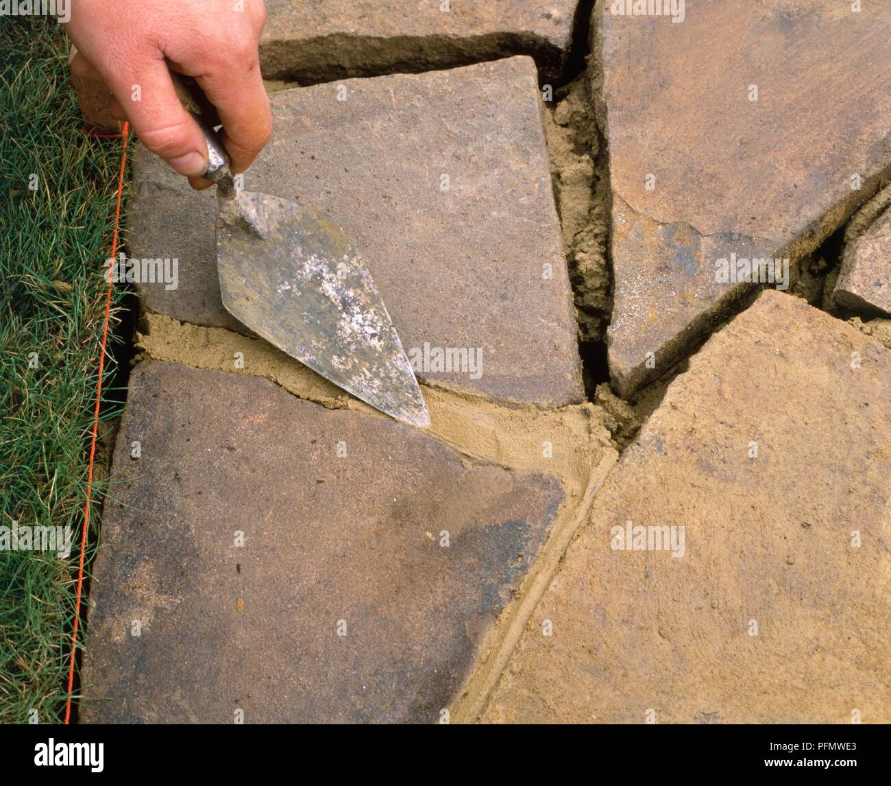 Using a trowel to bevel mortar between crazy paving, closeup Stock Photo Alamy