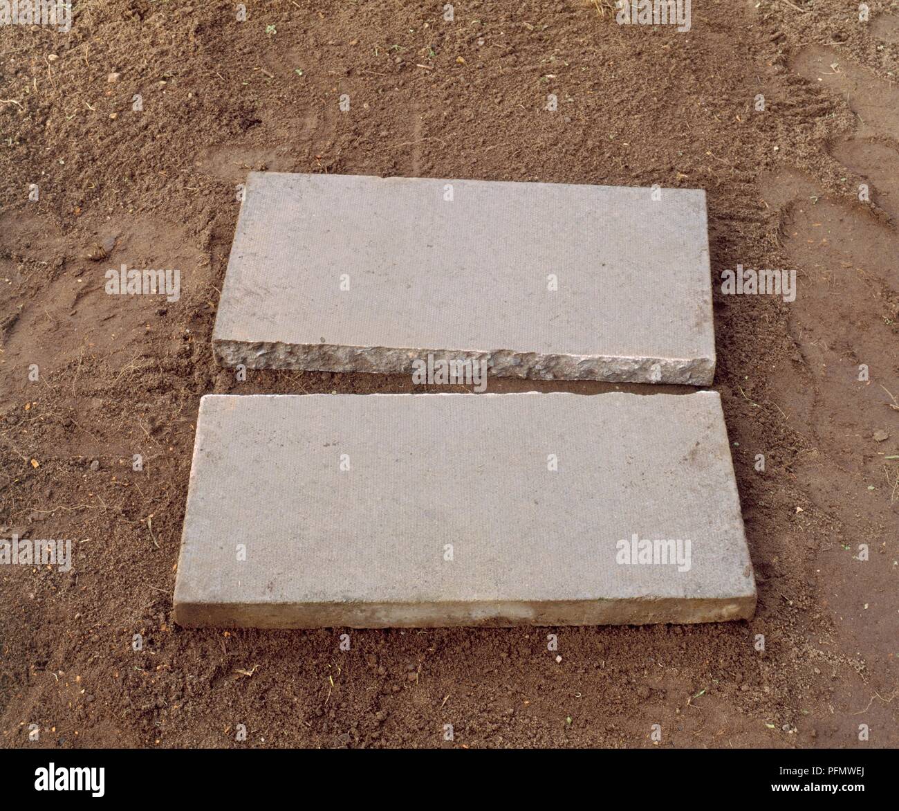Split paving slab on soil Stock Photo Alamy