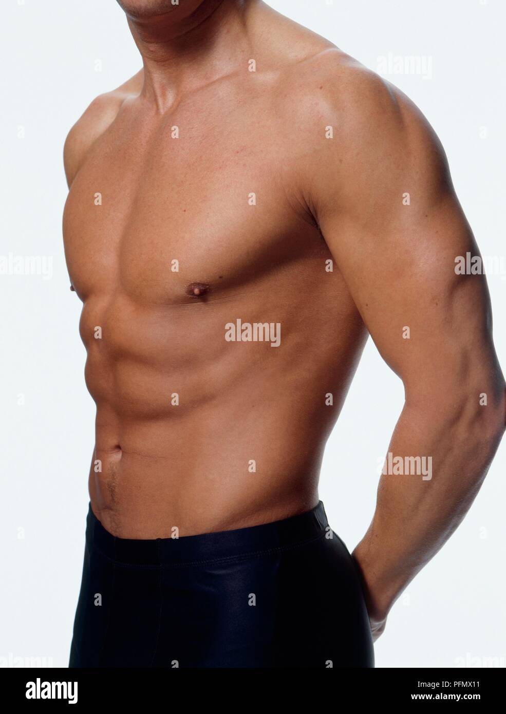 Man showing well-defined chest, abdominal, and arm muscles Stock