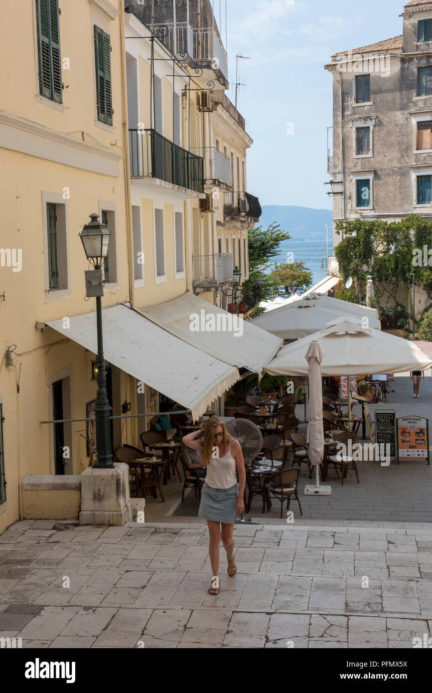 young and attractive woman walking through the old town at kerkyra on the greek island of corfu. Stock Photo