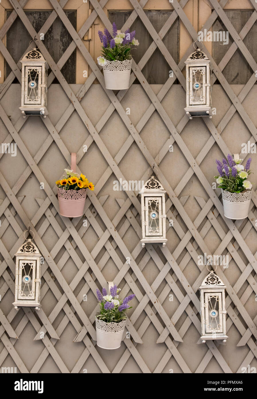 decorative flowers and lanterns hanging on some garden trellis for decorations . Stock Photo