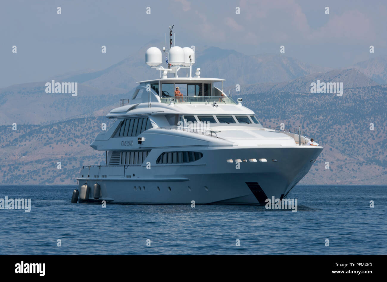 a superyacht moored in a bay on the greek island of corfu at anchor. Coastal Albania in the background with mountains and hills. Stock Photo