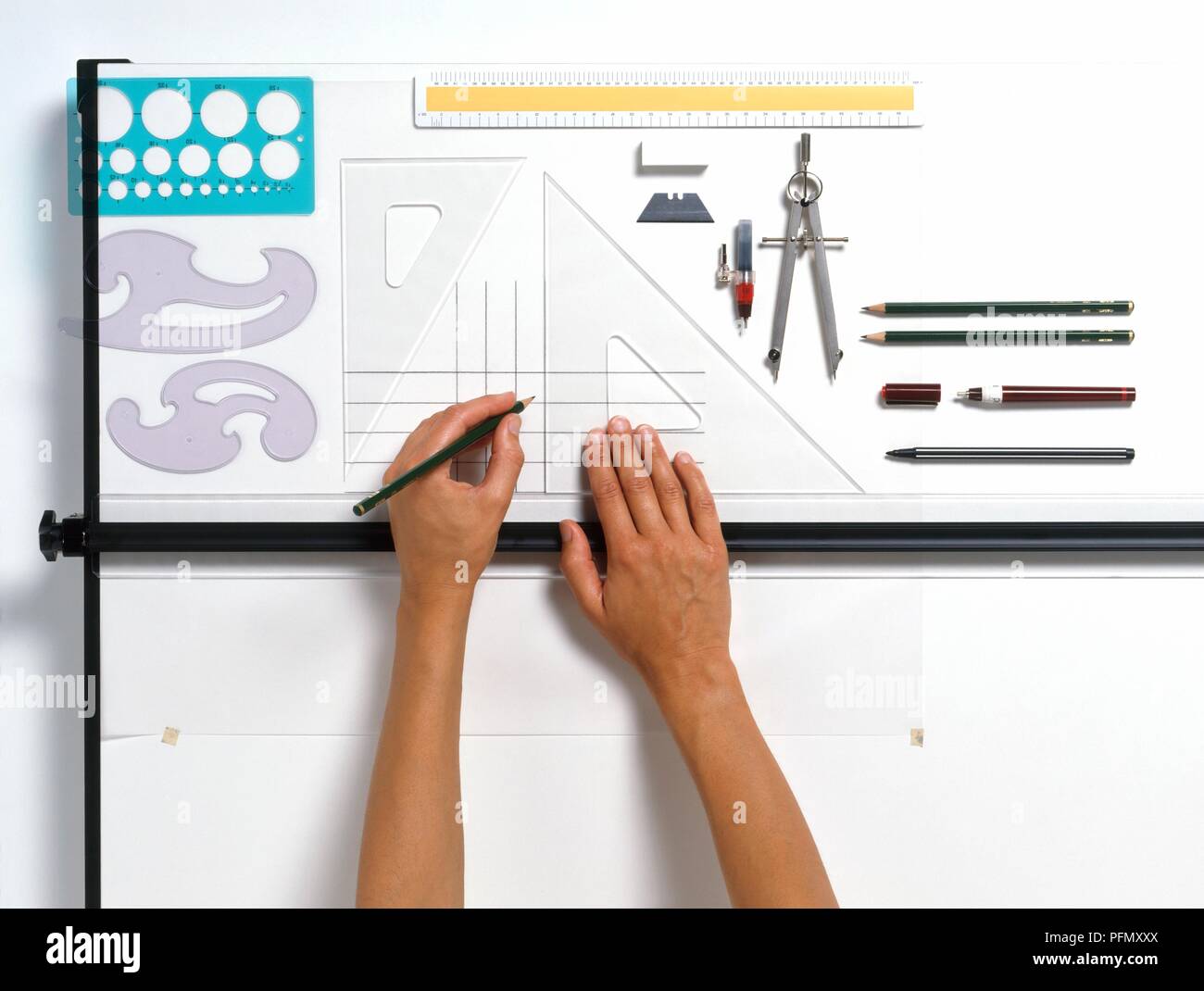 Set of drawing equipment laid out around drawing of simple grid, on