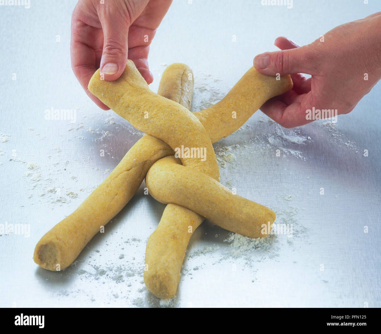 Folding over lengths of dough to form a dough plait Stock Photo Alamy