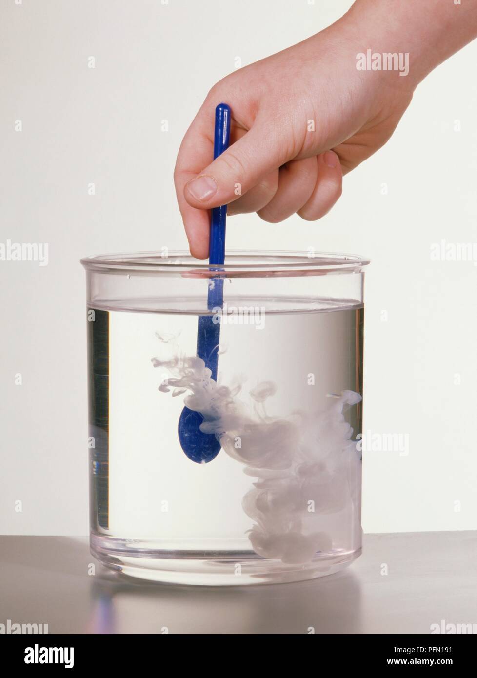 Stirring milk into water in a glass beaker Stock Photo - Alamy