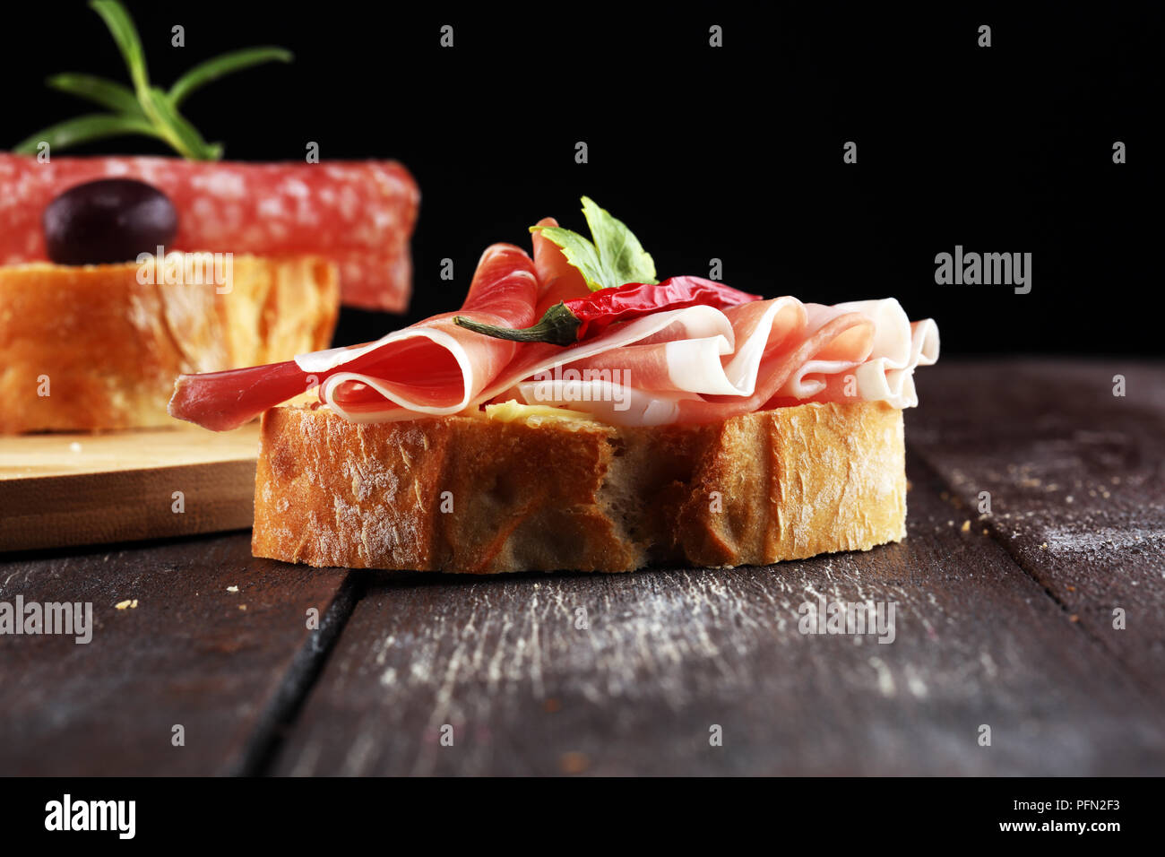 Sandwich with prosciutto or salami or crudo. Antipasti gourmet