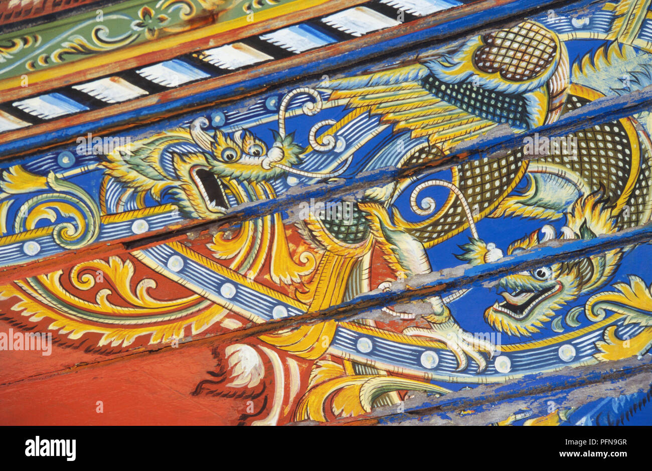 Thailand, intricately painted battling dragons on the side of decorated korlae boat. Stock Photo