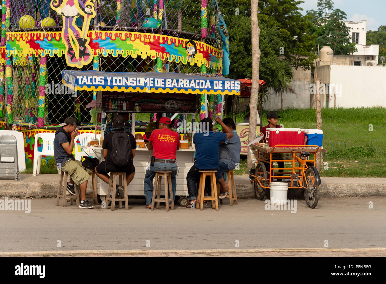 Tulum, Mexico - 7 August 2018: People eating tacos at a colorful mexican food stand. Stock Photo