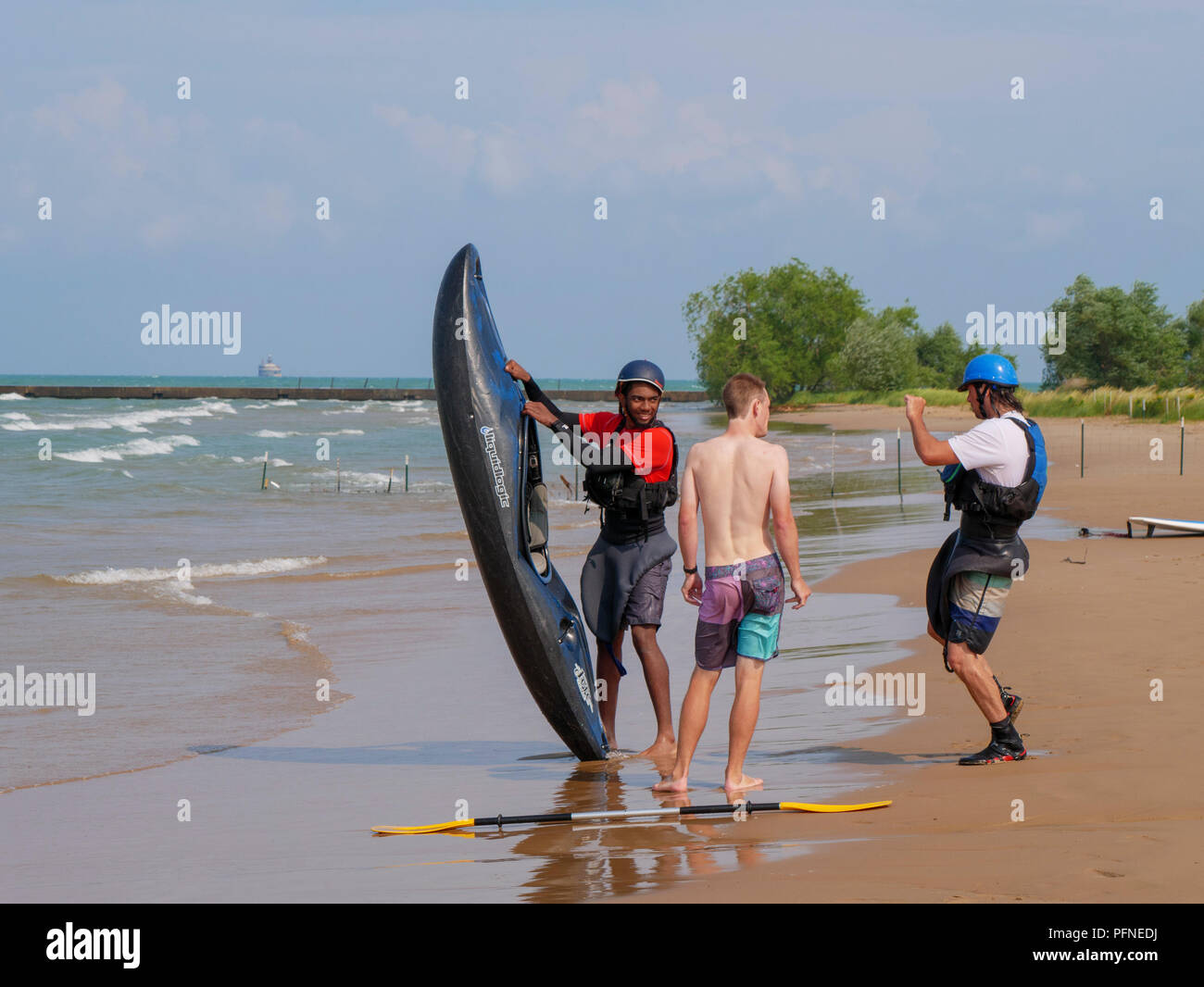 Chicago, Illinois, USA. 21st August 2018. A kayaker poses for a photo before heading out into the surf at Montrose Beach. Stiff northeast winds whipped up surf on Lake Michigan, bringing out kayakers, kite surfers and wave watchers. Credit: Todd Bannor/Alamy Live News Stock Photo