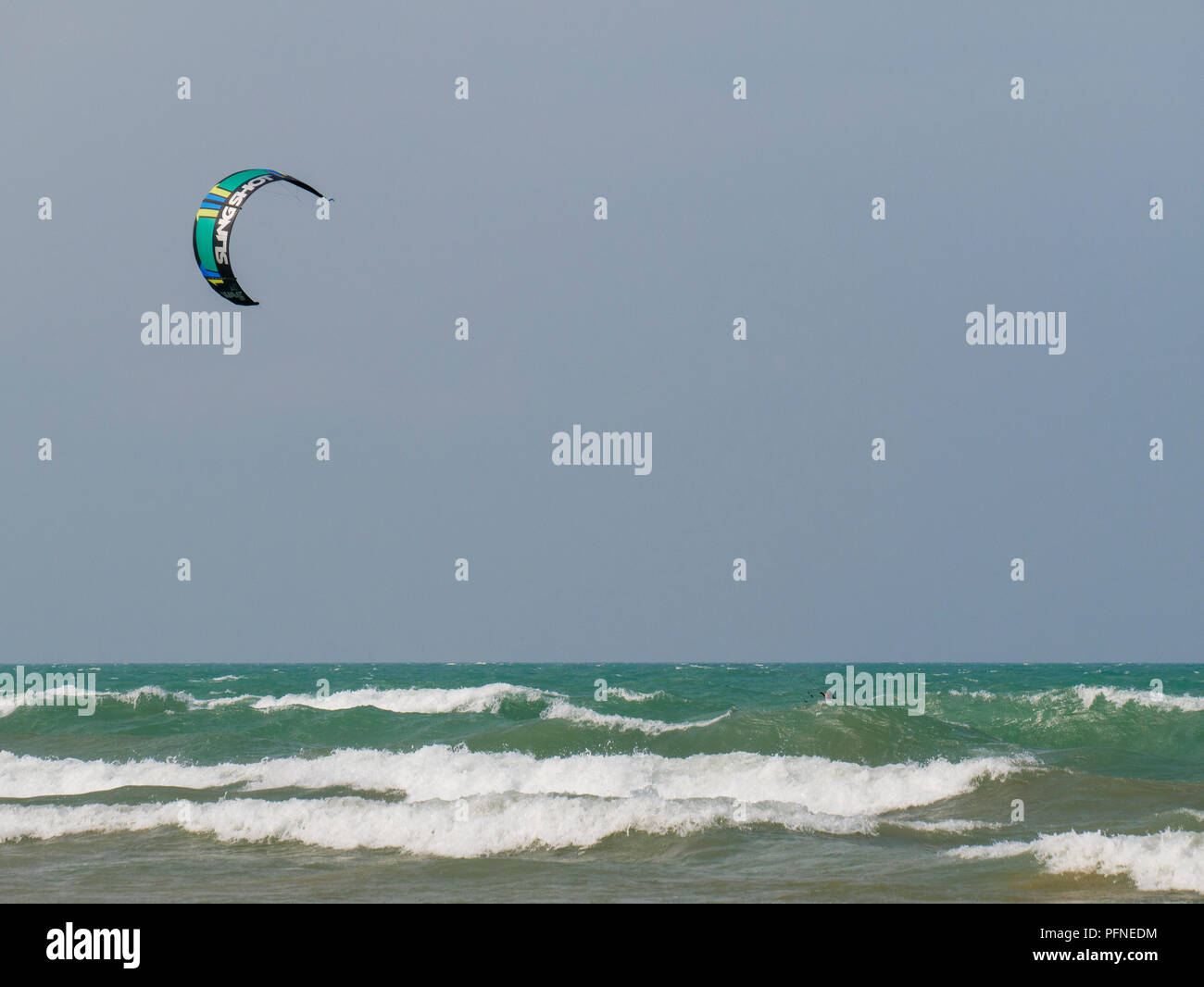 Chicago, Illinois, USA. 21st August 2018. A kite surfer mostly hidden behind a wave braves the surf at Montrose Beach. Stiff northeast winds whipped up surf on Lake Michigan, bringing out kayakers, kite surfers and wave watchers. Credit: Todd Bannor/Alamy Live News Stock Photo