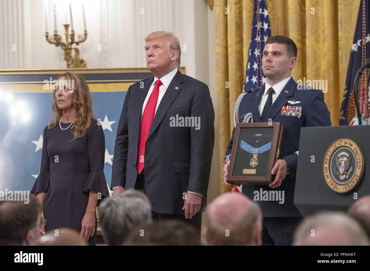 Washington, District of Columbia, USA. 22nd Aug, 2018. Valerie Nessel, widow of Technical Sergeant John A. Chapman, United States Air Force, left, stands with US President Donald J. Trump, center, makes remarks as she accepts the Medal of Honor posthumously from the President during a ceremony in the East Room of the White House in Washington, DC on Wednesday, August 22, 2018. Sergeant Chapman is being honored for his actions on March 4, 2002, on Takur Ghar mountain in Afghanistan where he gave his life to save his teammates Credit: Ron Sachs/CNP/ZUMA Wire/Alamy Live News Stock Photo