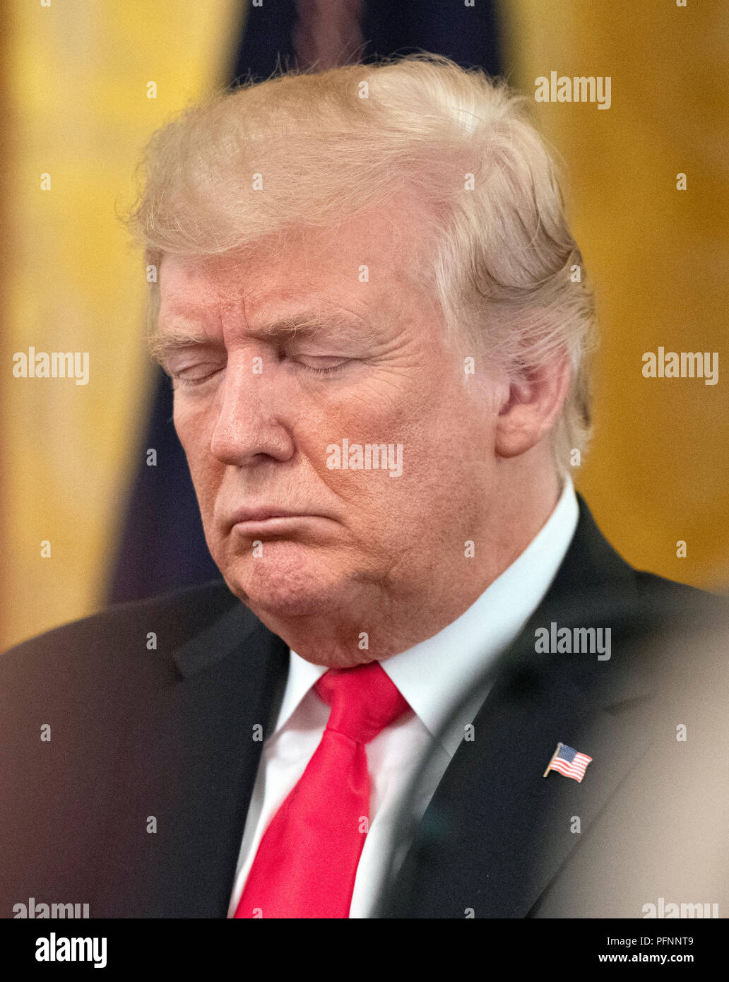 United States President Donald J. Trump bows his head in prayer prior to his making remarks as he awards the Medal of Honor posthumously to Technical Sergeant John A. Chapman, US Air Force, during a ceremony in the East Room of the White House in Washington, DC on Wednesday, August 22, 2018. Sergeant Chapman is being honored for his actions on March 4, 2002, on Takur Ghar mountain in Afghanistan where he gave his life to save his teammates. Credit: Ron Sachs/CNP | usage worldwide Stock Photo