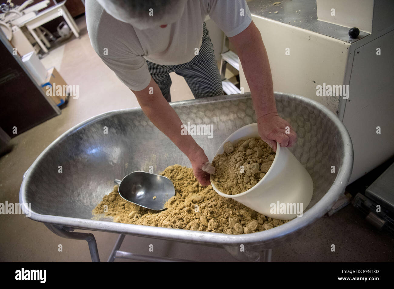 Straubenhardt, Germany. 11th July, 2018. Markus Hoell, employee of a pasta factory, which among other things produces for Plumento Food GmbH, takes powder from freeze-dried larvae of a grain mold beetle (Alphitobius diaperinus), also known as Buffalo worm, from a tub. Plumento Food develops and sells products that contain, among other things, insect meal. Credit: Marijan Murat/dpa/Alamy Live News Stock Photo