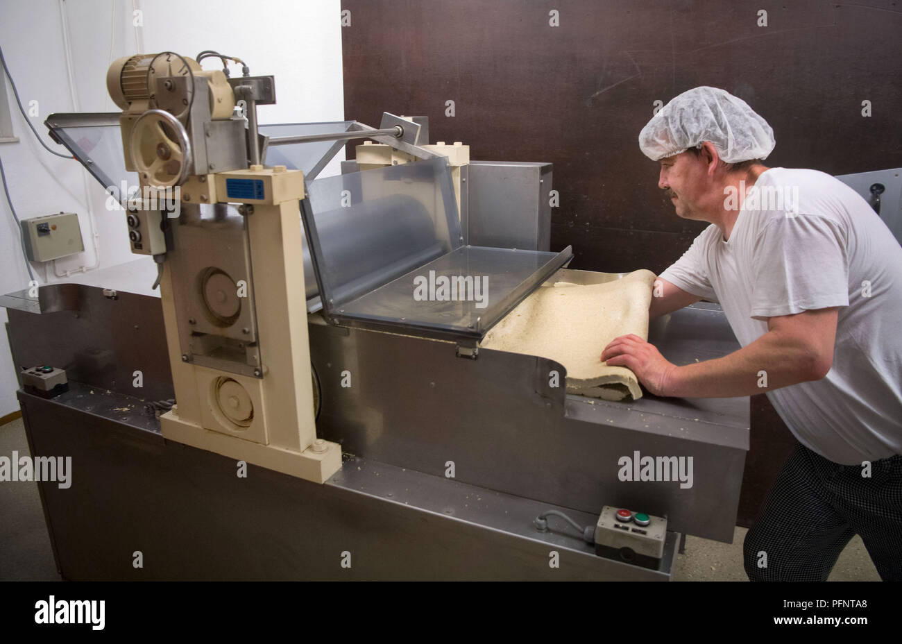 Straubenhardt, Germany. 11th July, 2018. Markus Hoell, employee of a pasta factory, which among other things produces for Plumento Food GmbH, operates a pasta machine on which insect-containing pasta dough is rolled. Plumento Food develops and sells products containing, among other things, insect meal. Credit: Marijan Murat/dpa/Alamy Live News Stock Photo