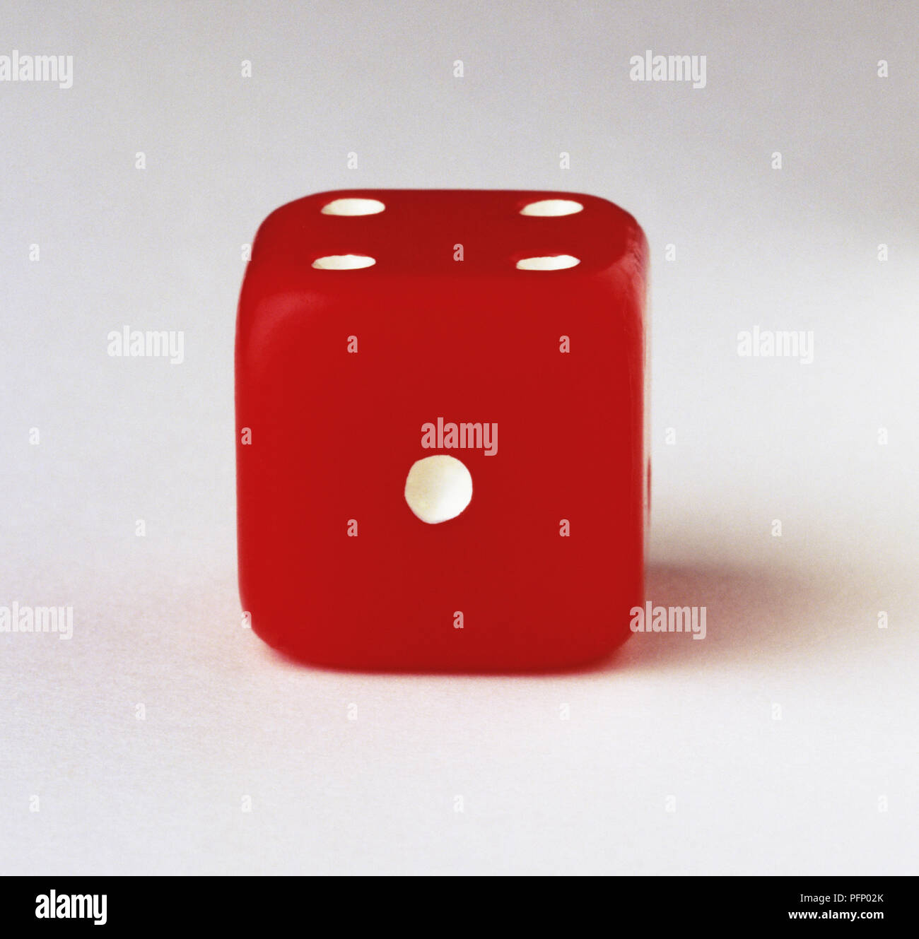 Red dice with one-dot side facing the camera, close up Stock Photo