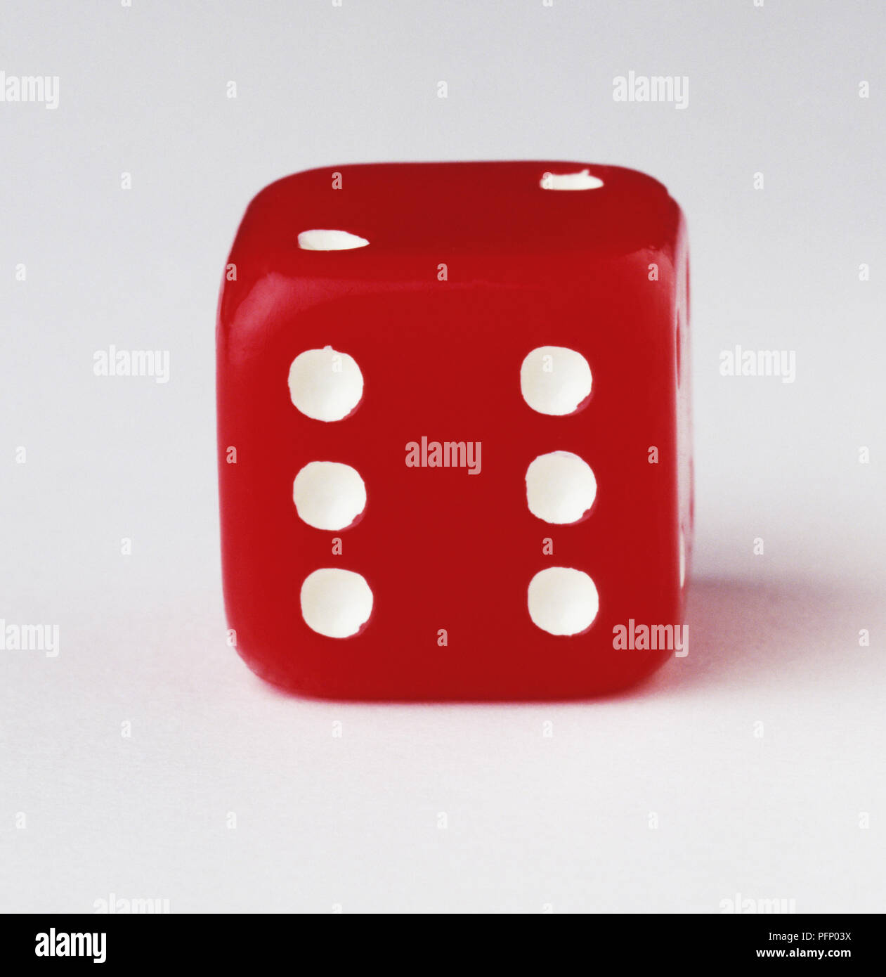 Red dice with six-dot side facing the camera, close up Stock Photo