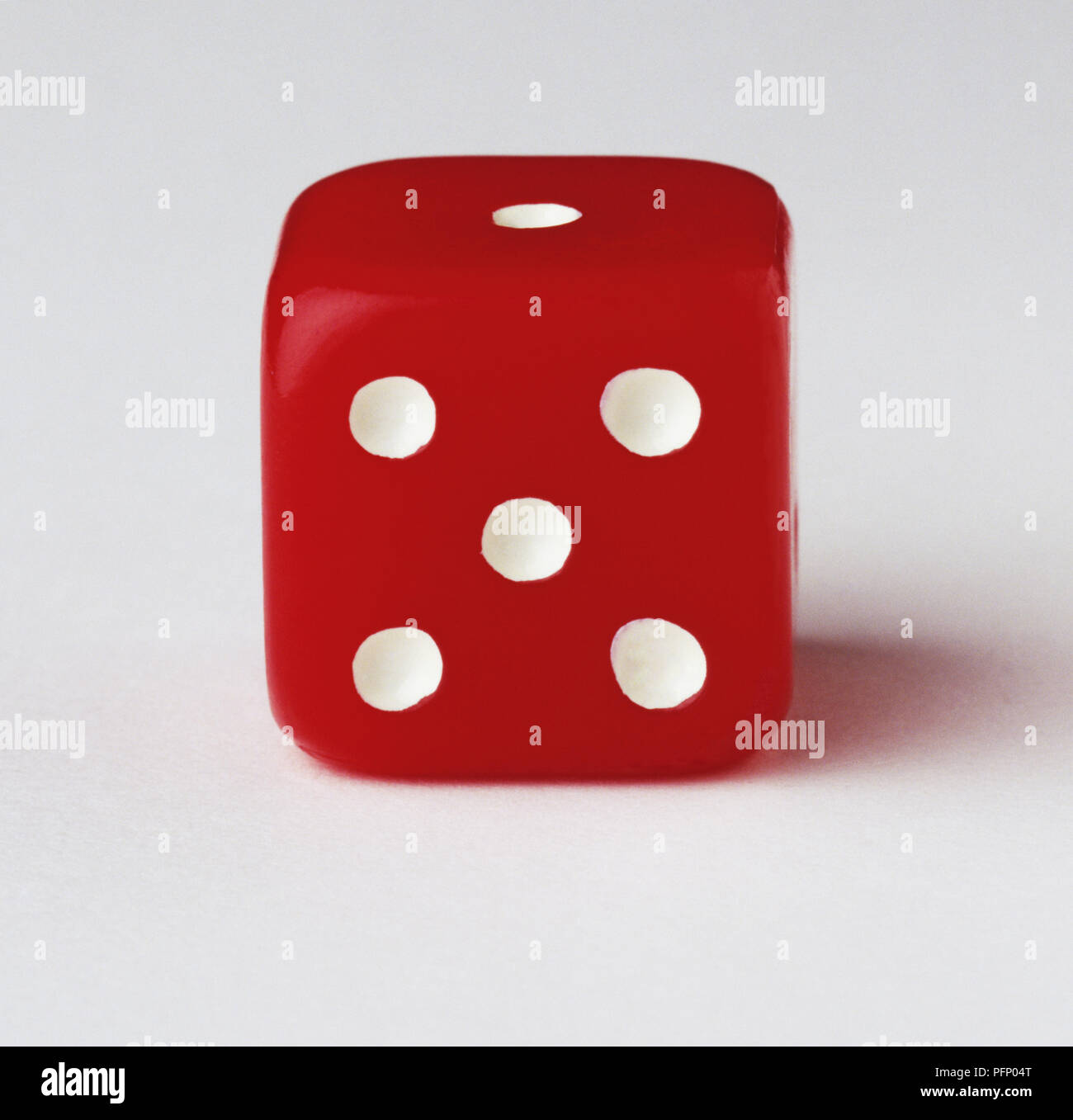 Red dice with five-dot side facing the camera, close up Stock Photo
