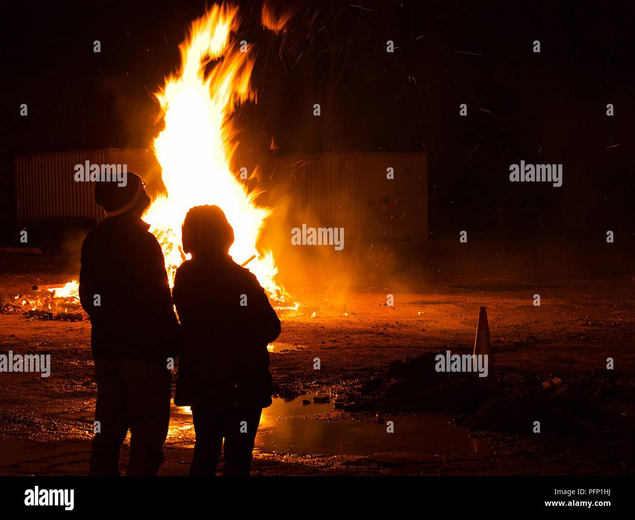 Couple watching a bonfire Stock Photo