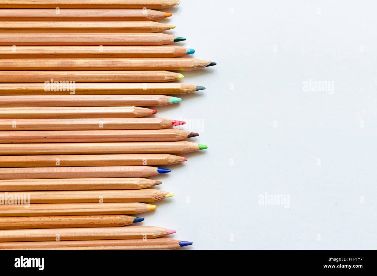 Wooden color pencils on empty white paper. Minimalist template with ...